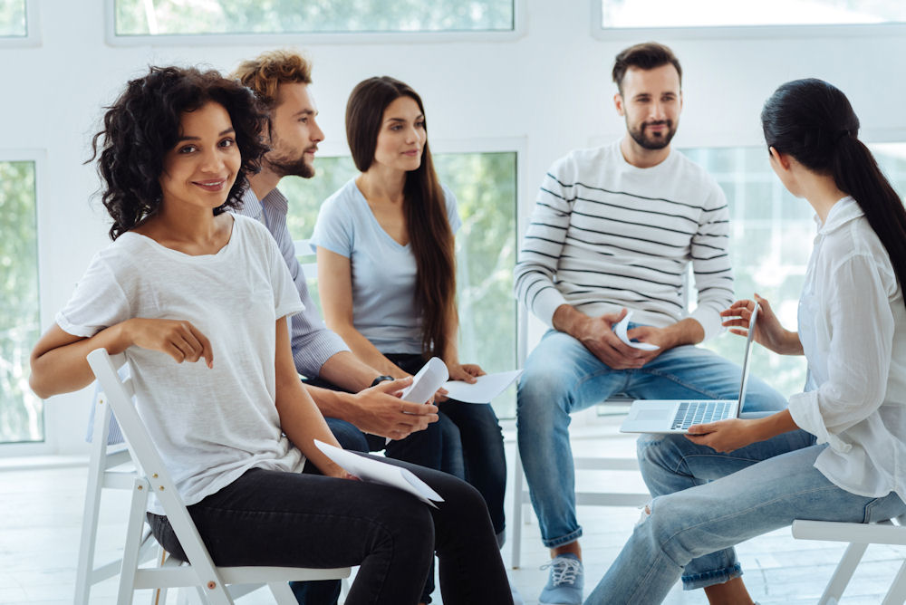 woman in group therapy session turned toward camera