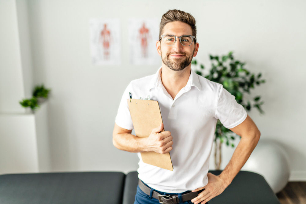 male counselor for addiction holding a clipboard