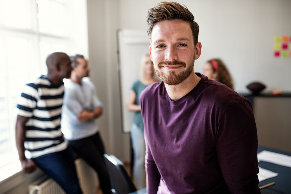 man smiling in front of addiction recovery group