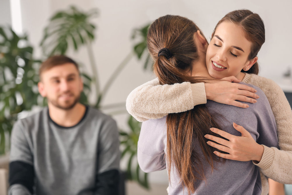 women hugging during therapy