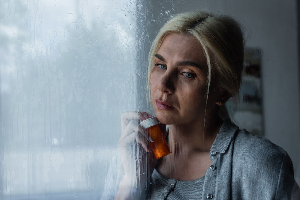 sad woman holding benzo pills