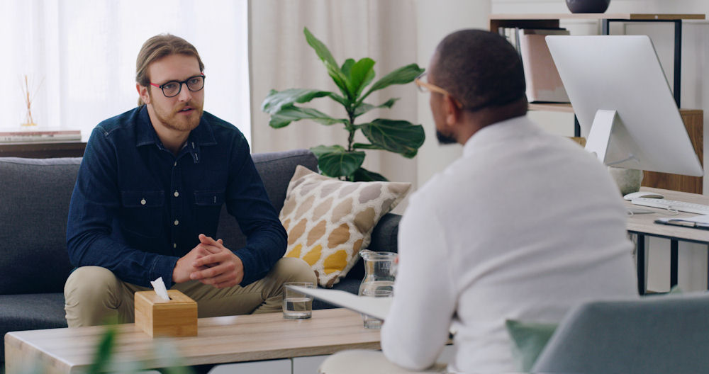man in individual therapy session talking to male counselor