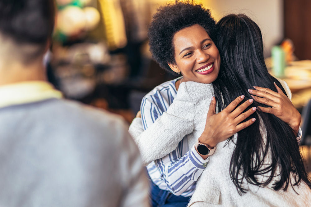 women hugging in group therapy