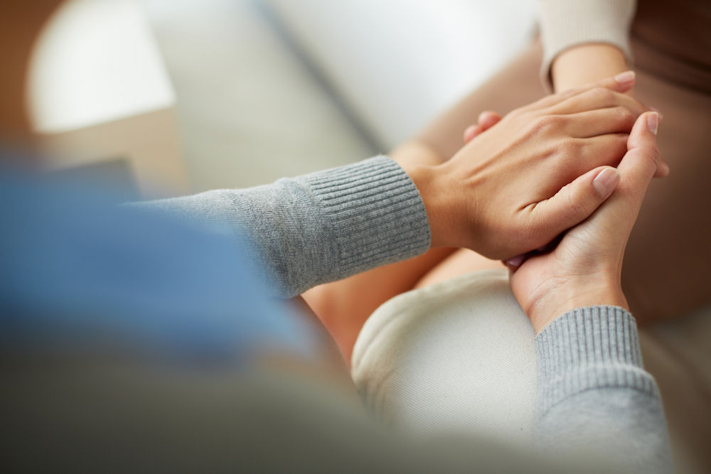 two individuals holding hands and showing support